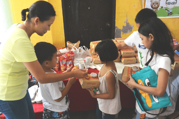 Dr Nam, Jake (6) and Max (9) distributing lunch.
