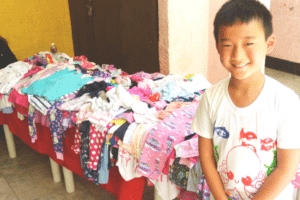 Here's Max with some kids' clothes, donated by our friends and family from Sydney