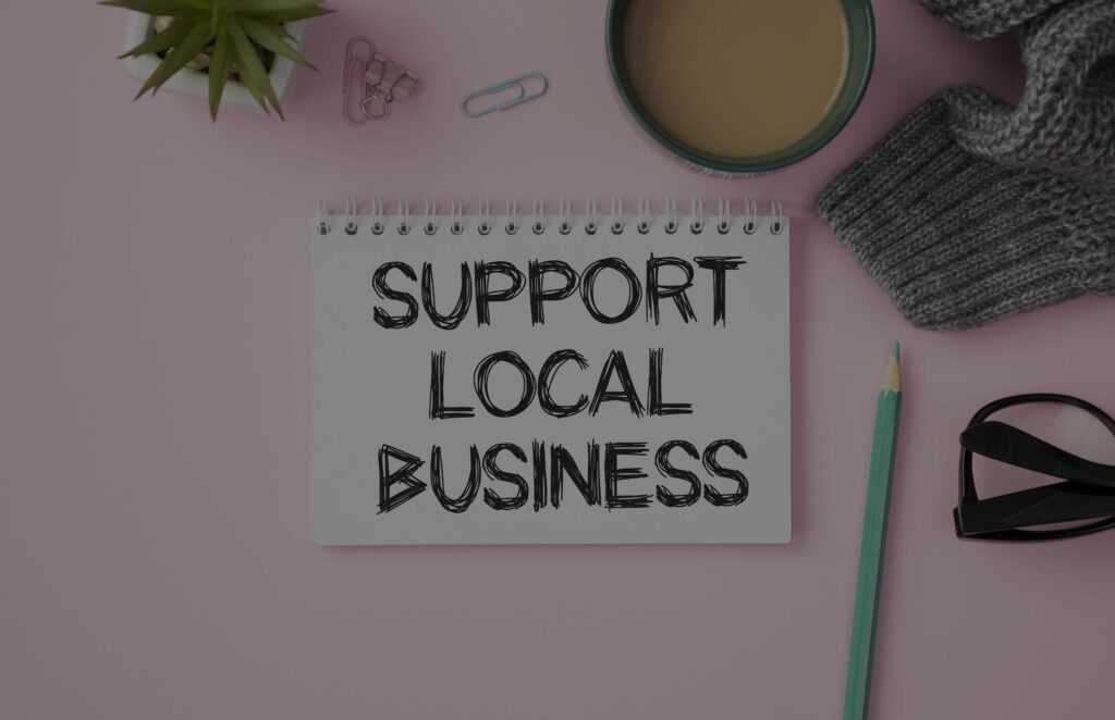 A pad of blank paper with the words SUPPORT LOCAL BUSINESS written on it
